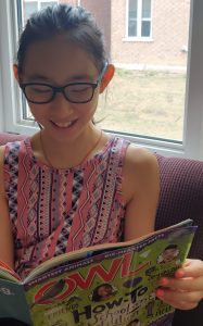 young girl reading a nature book